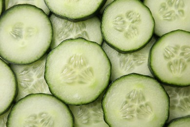 Fresh slices of cucumbers as background, top view