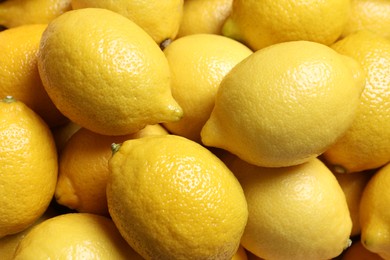 Photo of Fresh lemons as background, closeup. Citrus fruit