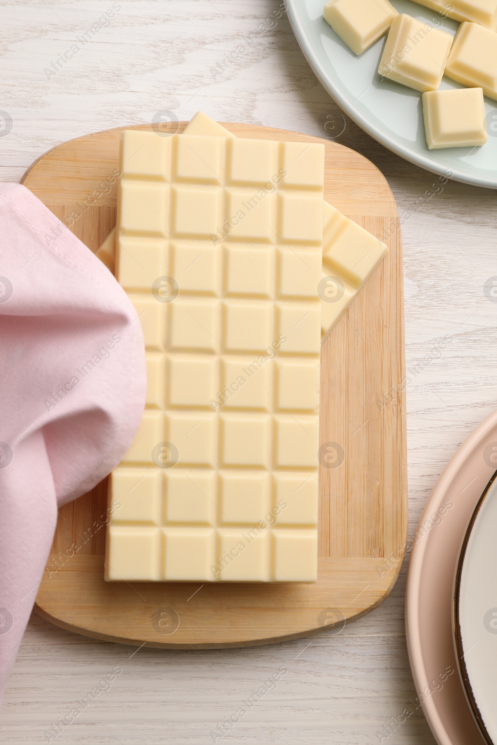 Photo of Delicious white chocolate on wooden table, flat lay