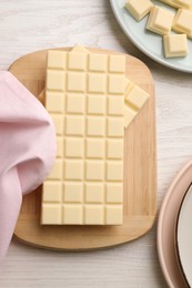 Delicious white chocolate on wooden table, flat lay