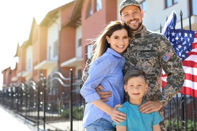 Photo of American soldier with family outdoors. Military service