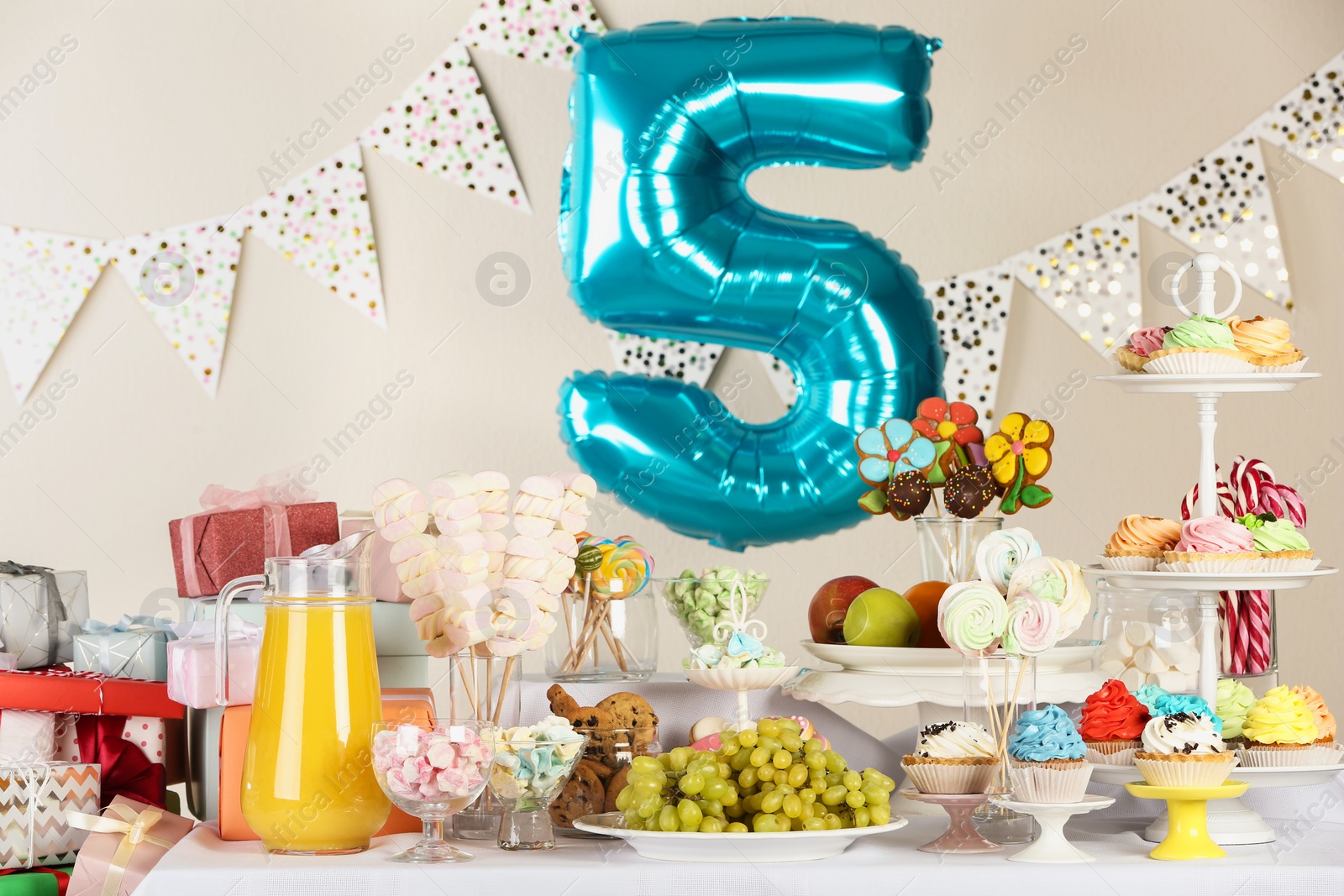 Photo of Blue number five balloon over table with delicious treats at Birthday party indoors