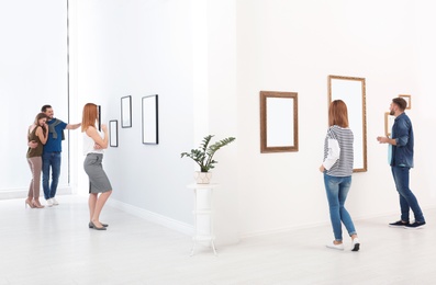 Photo of People viewing exposition in modern art gallery