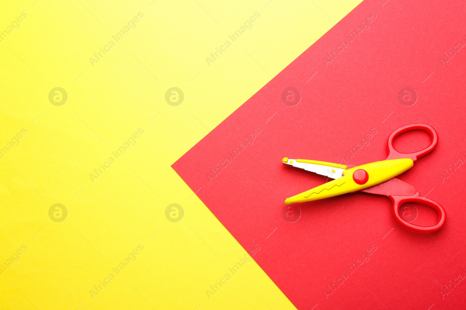 Photo of Decorative edge scissors on color background, top view. Space for text