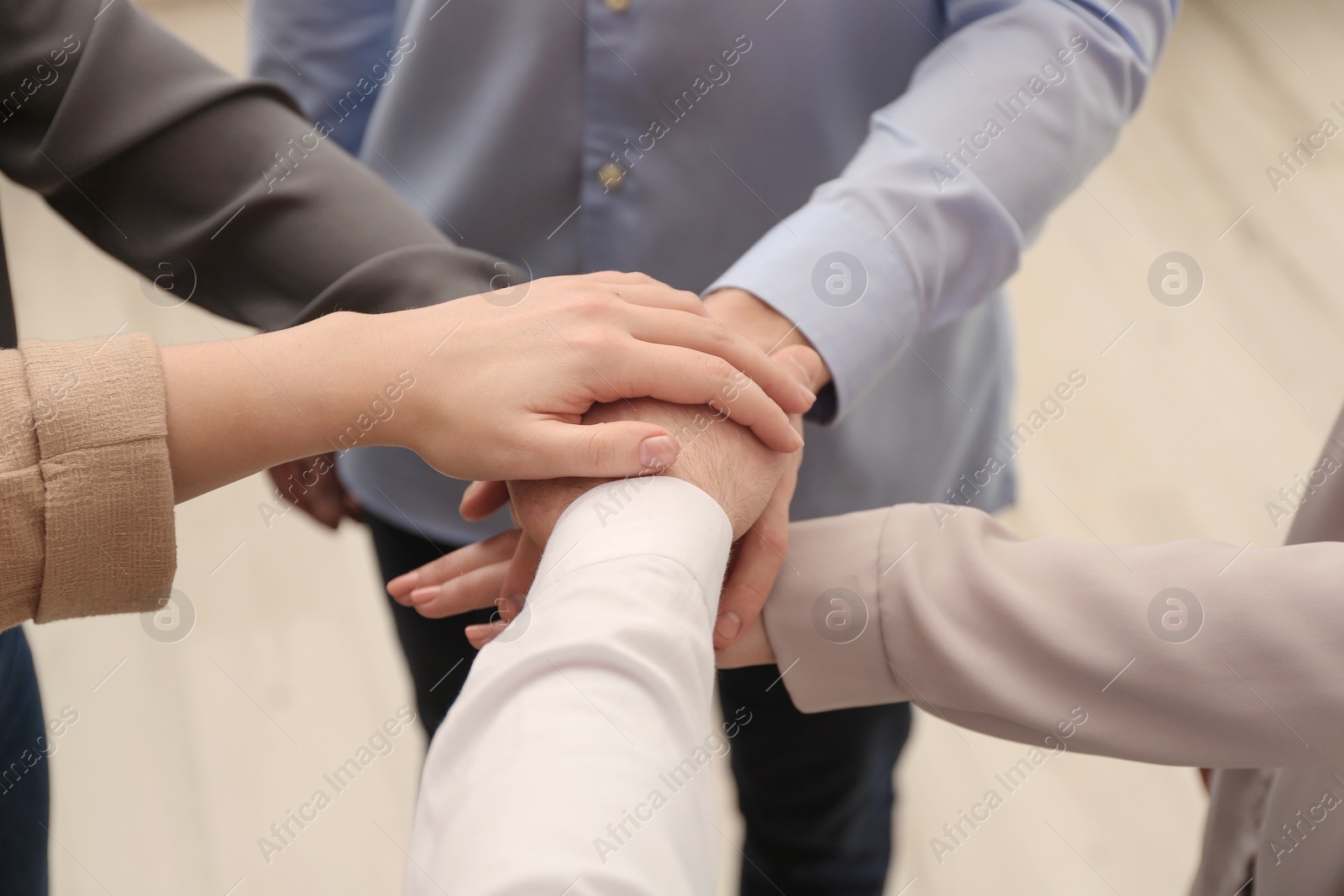 Photo of Group of people holding their hands together on blurred background, closeup