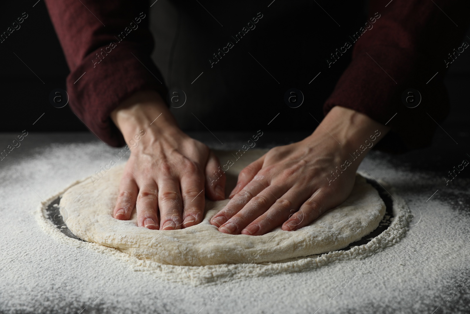 Photo of Woman kneading pizza dough at table, closeup