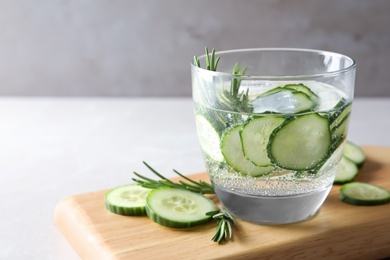 Glass of fresh cucumber water on table. Space for text