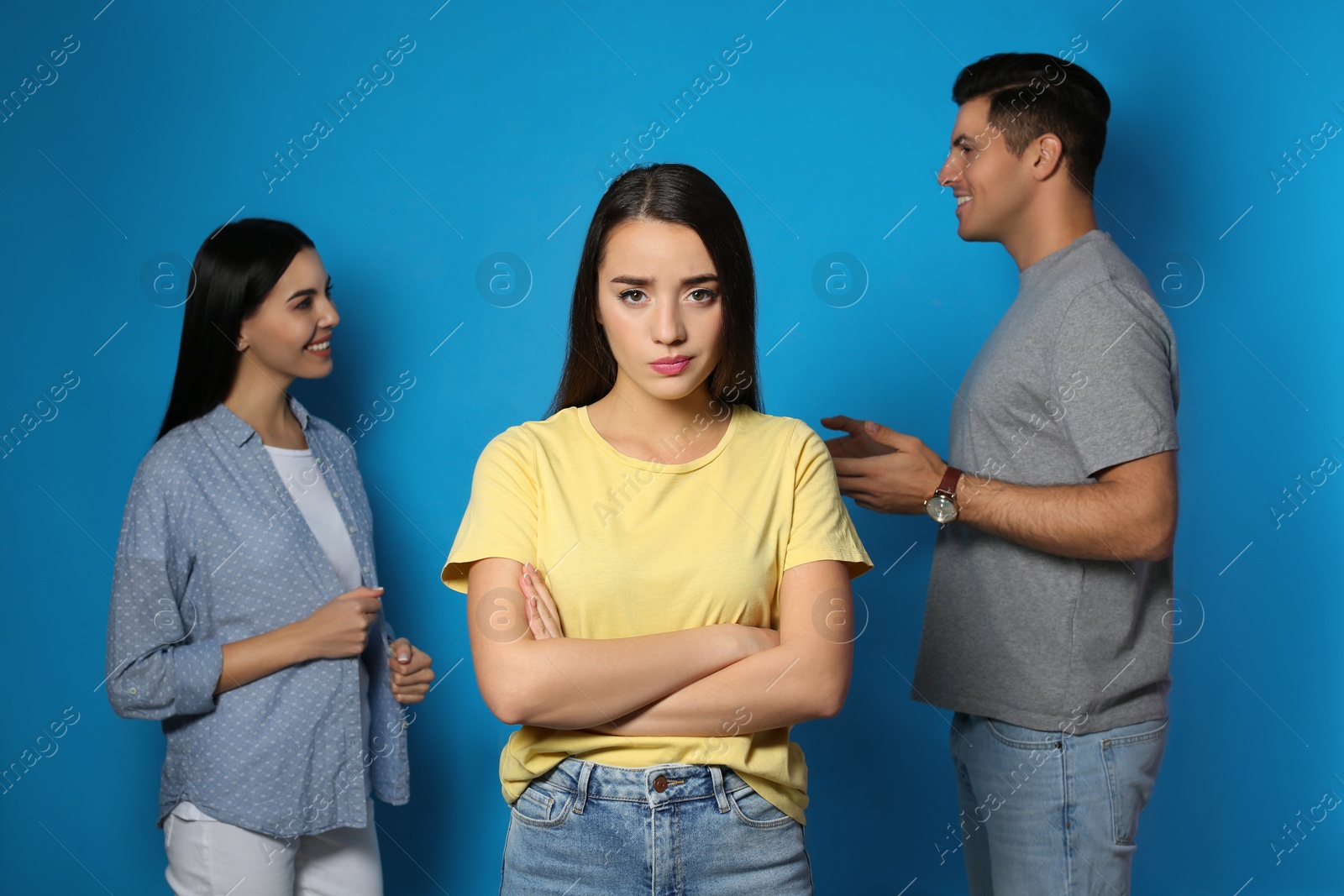 Photo of Unhappy woman feeling jealous while couple spending time together on blue background