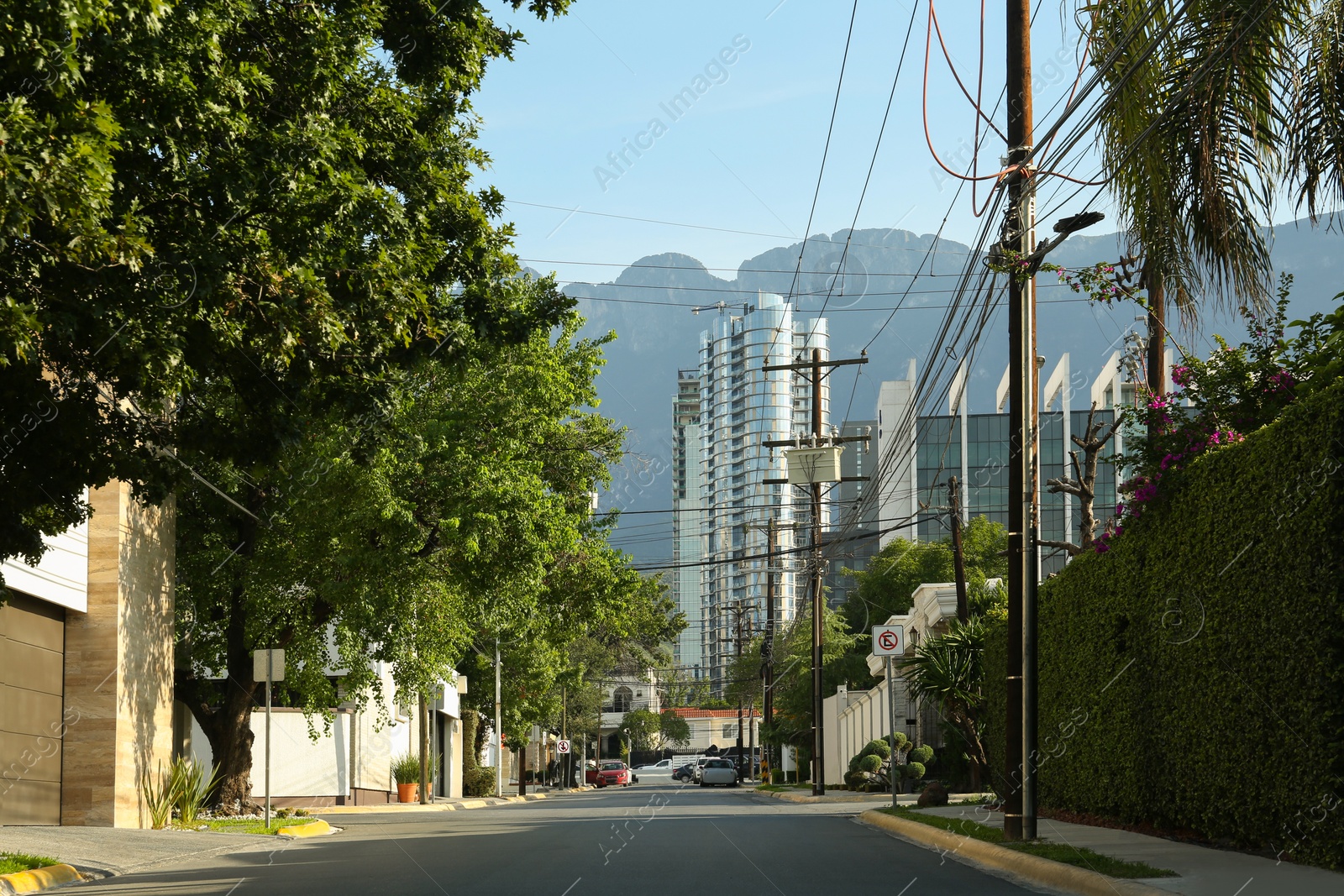 Photo of Picturesque view of mountains, city street with road and modern architecture