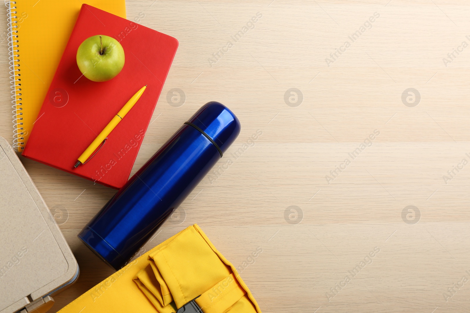 Photo of Flat lay composition with thermos and lunch box on wooden background, space for text