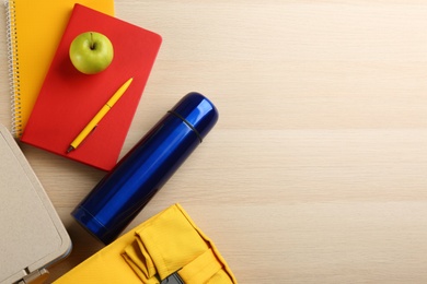Photo of Flat lay composition with thermos and lunch box on wooden background, space for text