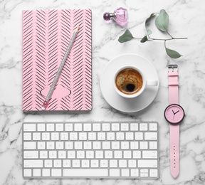 Flat lay composition with keyboard, coffee and notebook on white marble background