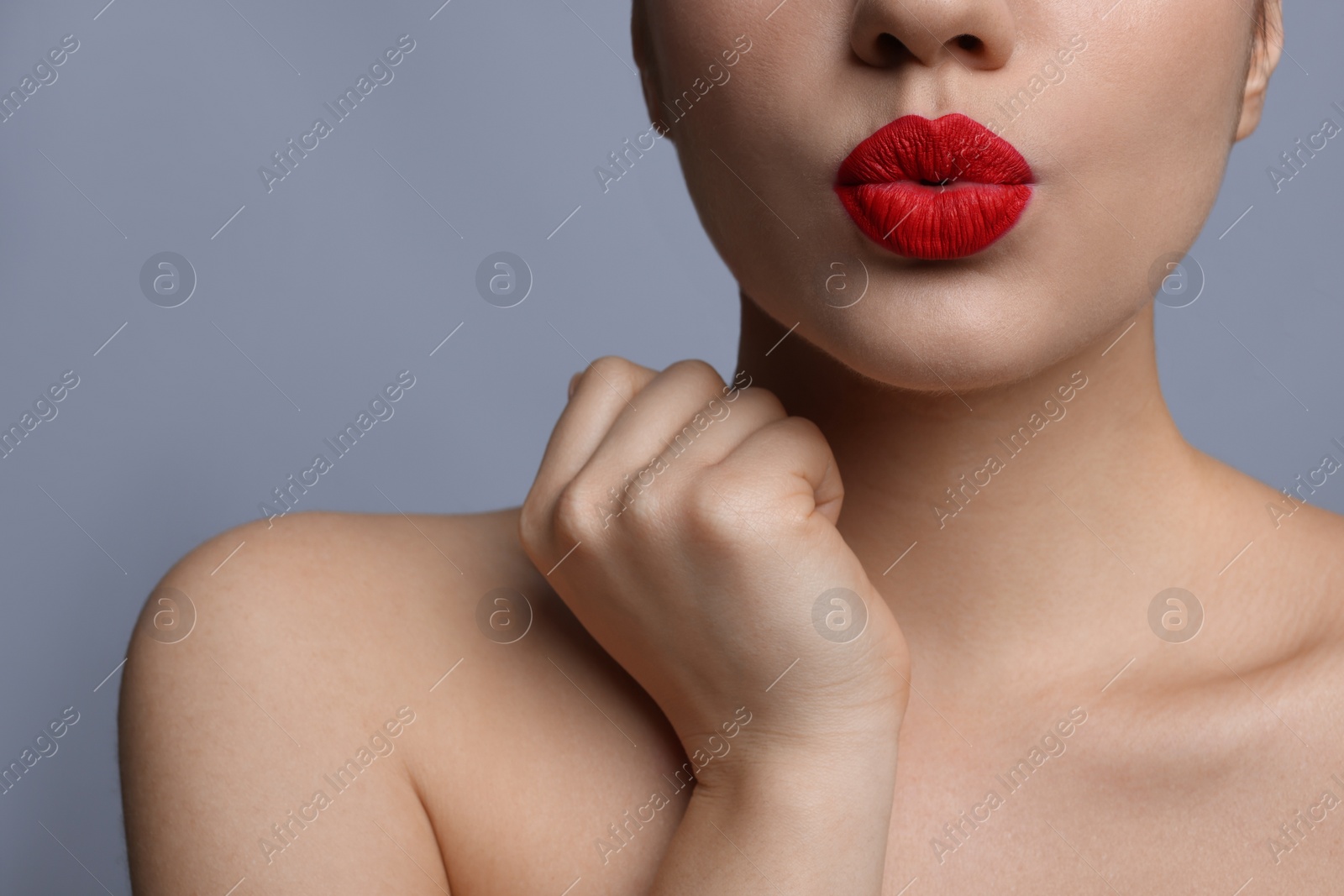 Photo of Closeup view of beautiful woman puckering lips for kiss	on grey background