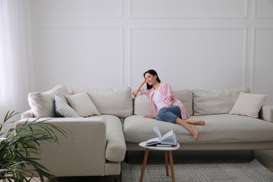 Photo of Woman resting on sofa in living room