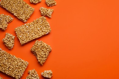 Puffed rice bars (kozinaki) on orange background, flat lay. Space for text