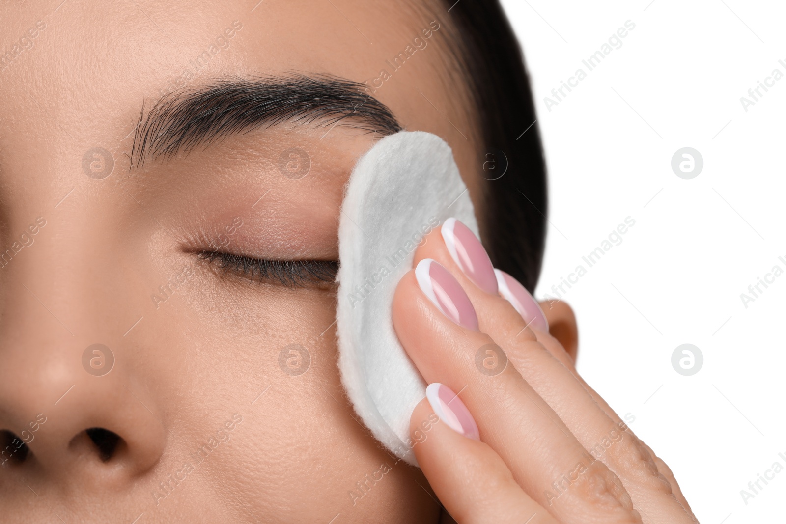 Photo of Beautiful woman removing makeup with cotton pad on white background, closeup