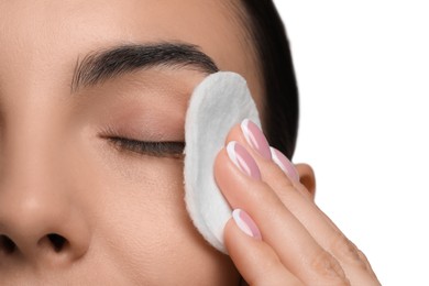 Photo of Beautiful woman removing makeup with cotton pad on white background, closeup