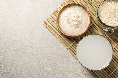 Flat lay composition with rice water on light grey table. Space for text