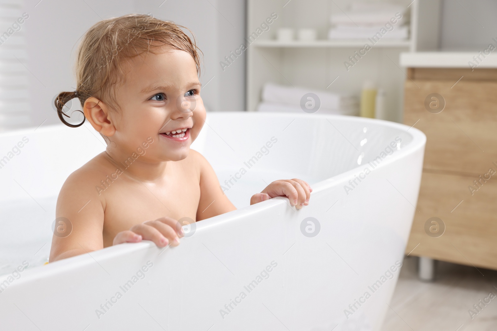 Photo of Cute little girl taking bath at home