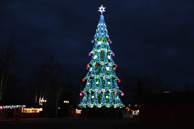 Photo of Beautiful decorated Christmas tree outdoors. Bokeh effect