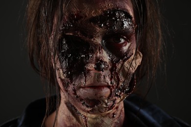 Photo of Scary zombie on dark background, closeup. Halloween monster