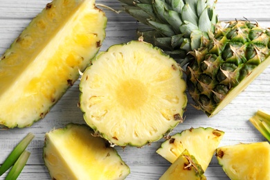 Flat lay composition with fresh sliced pineapple on wooden background