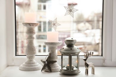 Photo of Decorative Christmas lantern and candles on windowsill