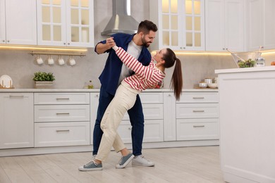 Happy lovely couple dancing together in kitchen