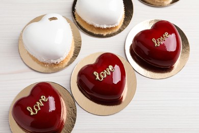 St. Valentine's Day. Delicious heart shaped cakes on white wooden table, flat lay