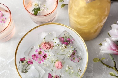 Photo of Composition with floral ice cubes and glasses on table, top view
