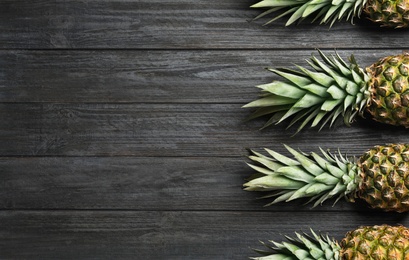 Photo of Flat lay composition with fresh juicy pineapples on wooden background, space for text