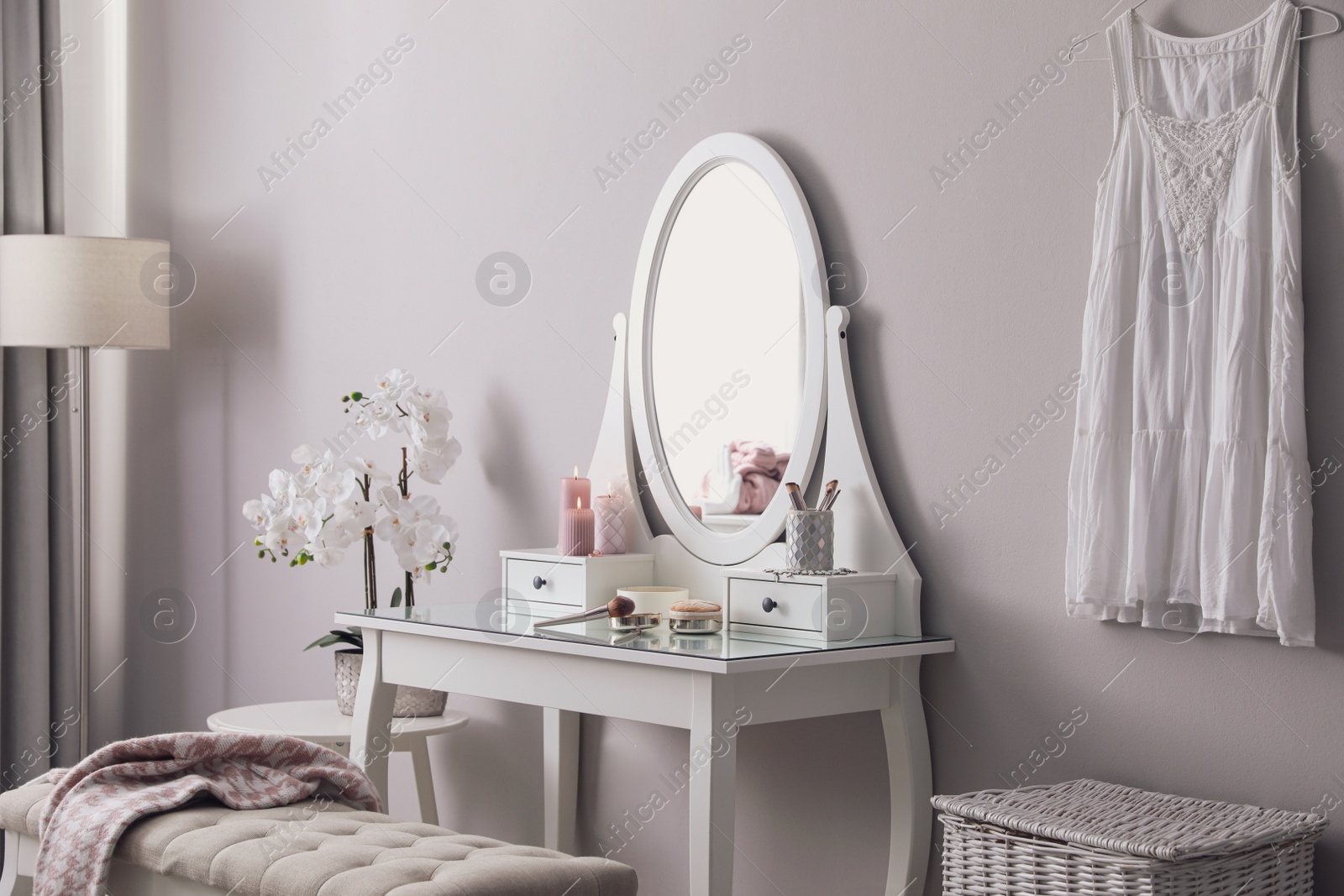 Photo of Wooden dressing table with decorative elements and makeup products in room. Interior design