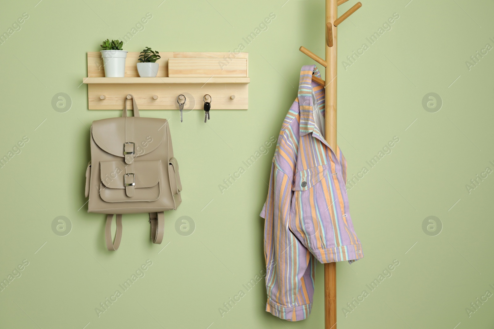 Photo of Wooden hanger for keys on light green wall
