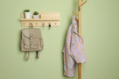 Wooden hanger for keys on light green wall