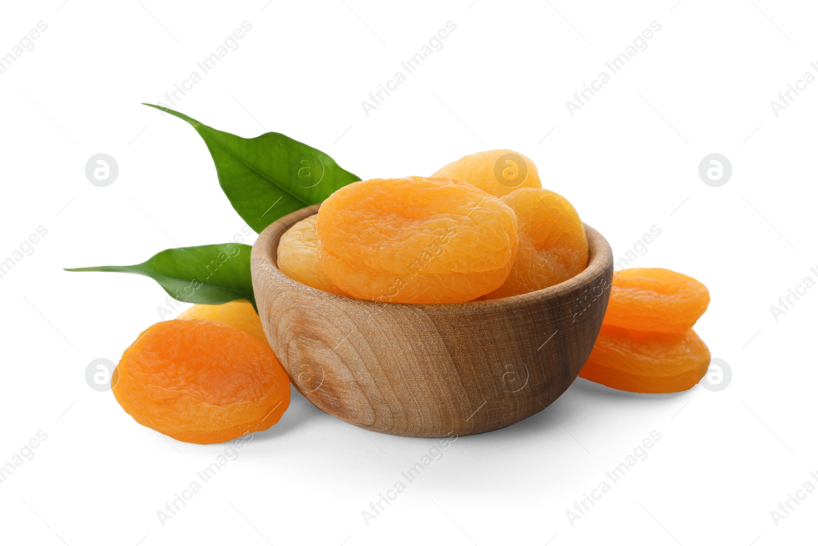 Photo of Wooden bowl with tasty dried apricots and leaves isolated on white