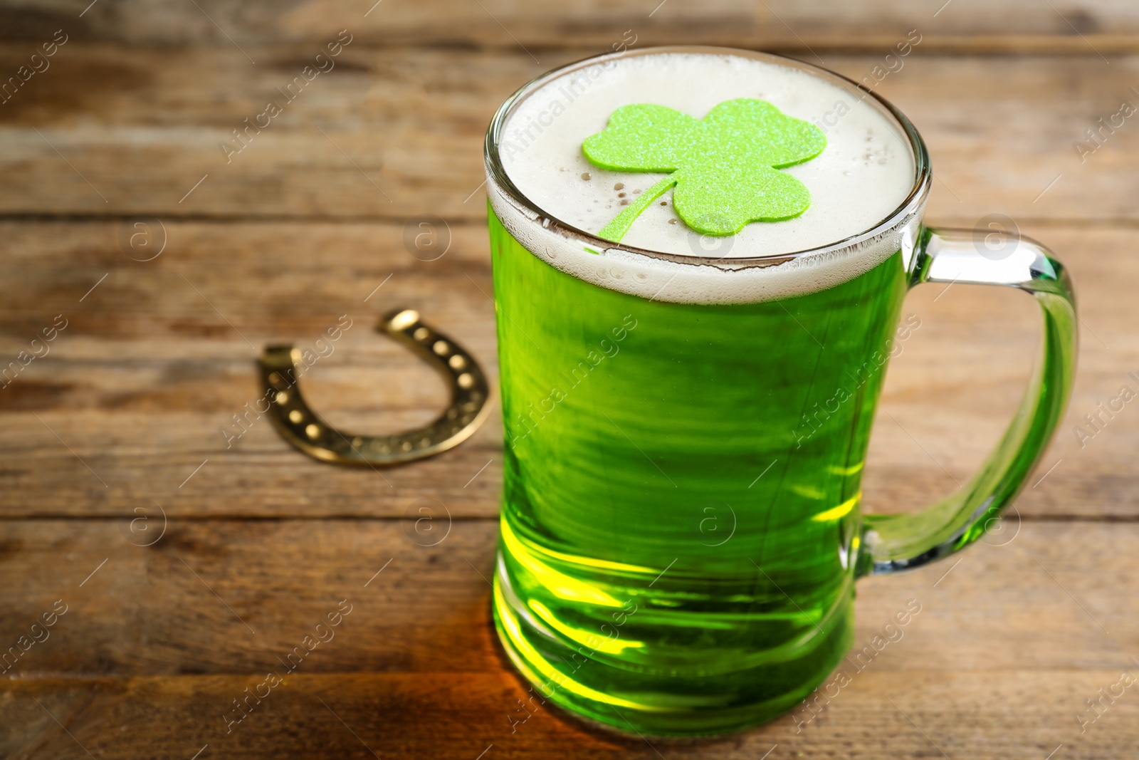 Photo of Green beer and clover on wooden table. St. Patrick's Day celebration