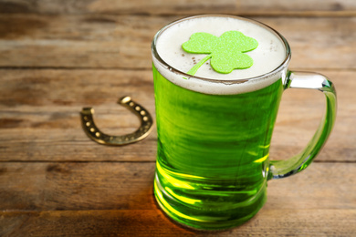 Photo of Green beer and clover on wooden table. St. Patrick's Day celebration