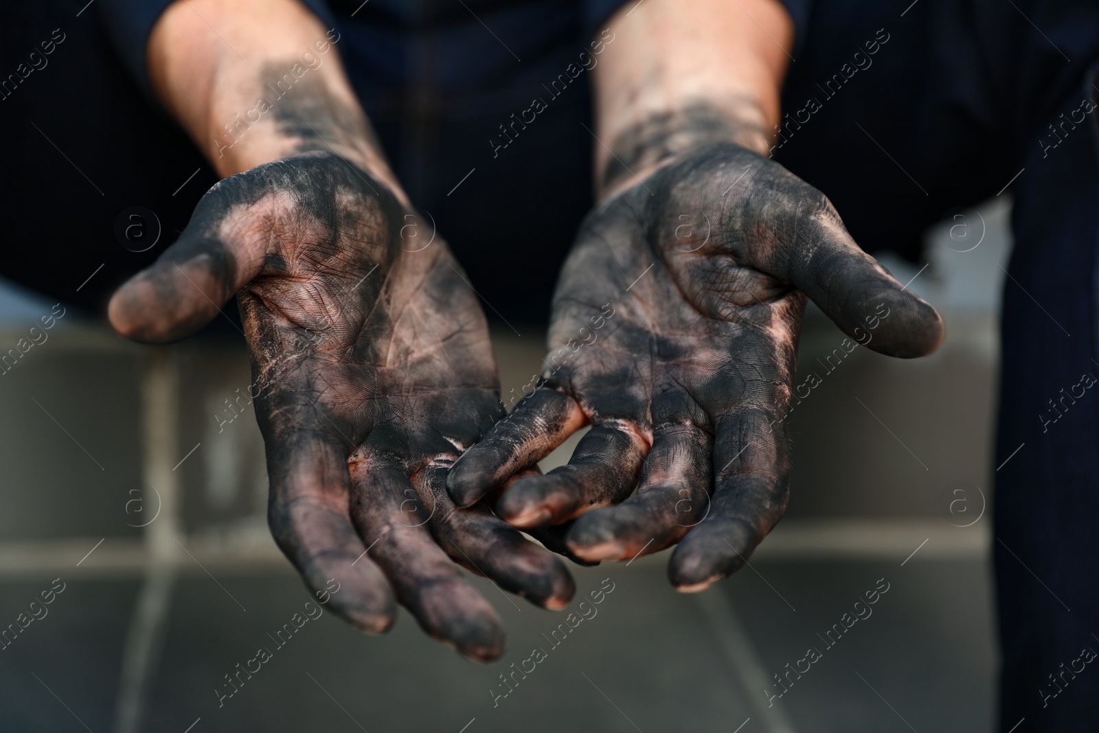 Photo of Dirty worker sitting on stairs, closeup of hands