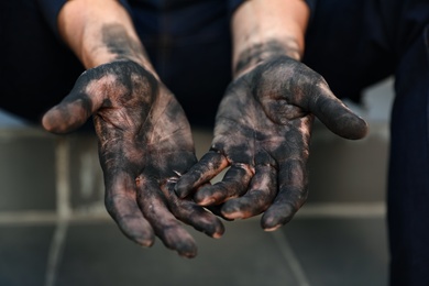 Photo of Dirty worker sitting on stairs, closeup of hands