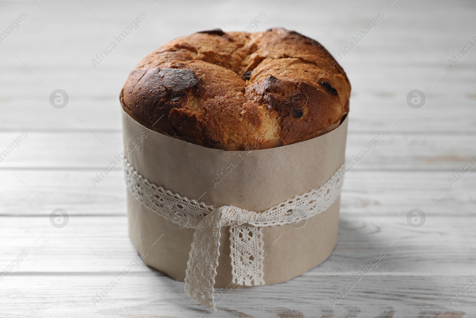 Photo of Delicious Panettone cake on white wooden table. Traditional Italian pastry