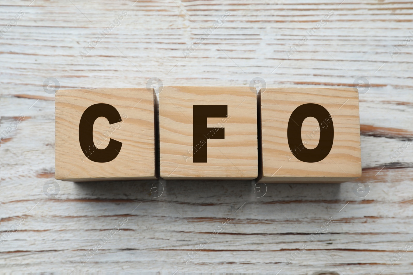 Photo of Abbreviation CFO of cubes on white wooden table, flat lay. Financial management