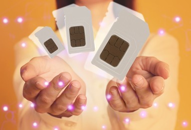 Woman demonstrating SIM cards of different sizes on yellow background, closeup 