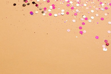 Photo of Shiny bright pink glitter on beige background. Space for text