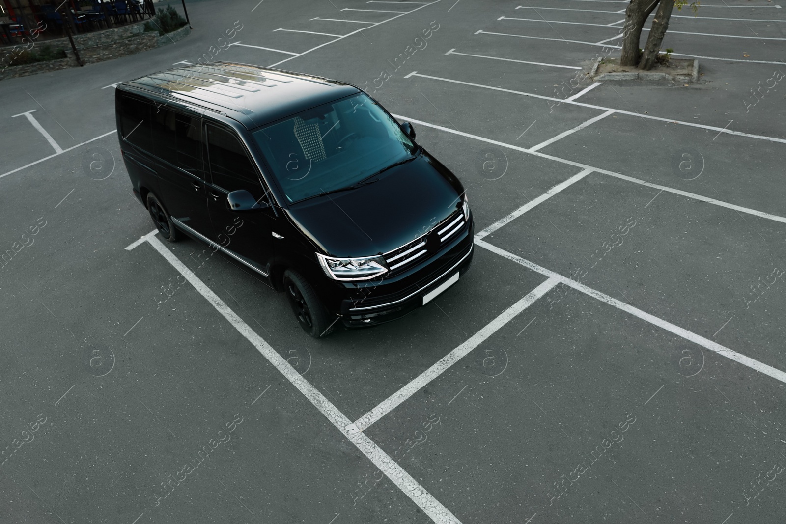 Photo of Black van on parking lot outdoors in morning