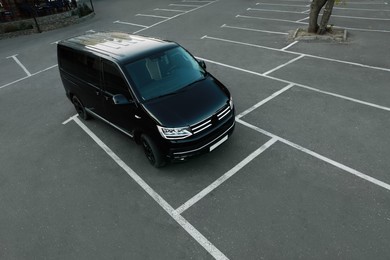 Black van on parking lot outdoors in morning