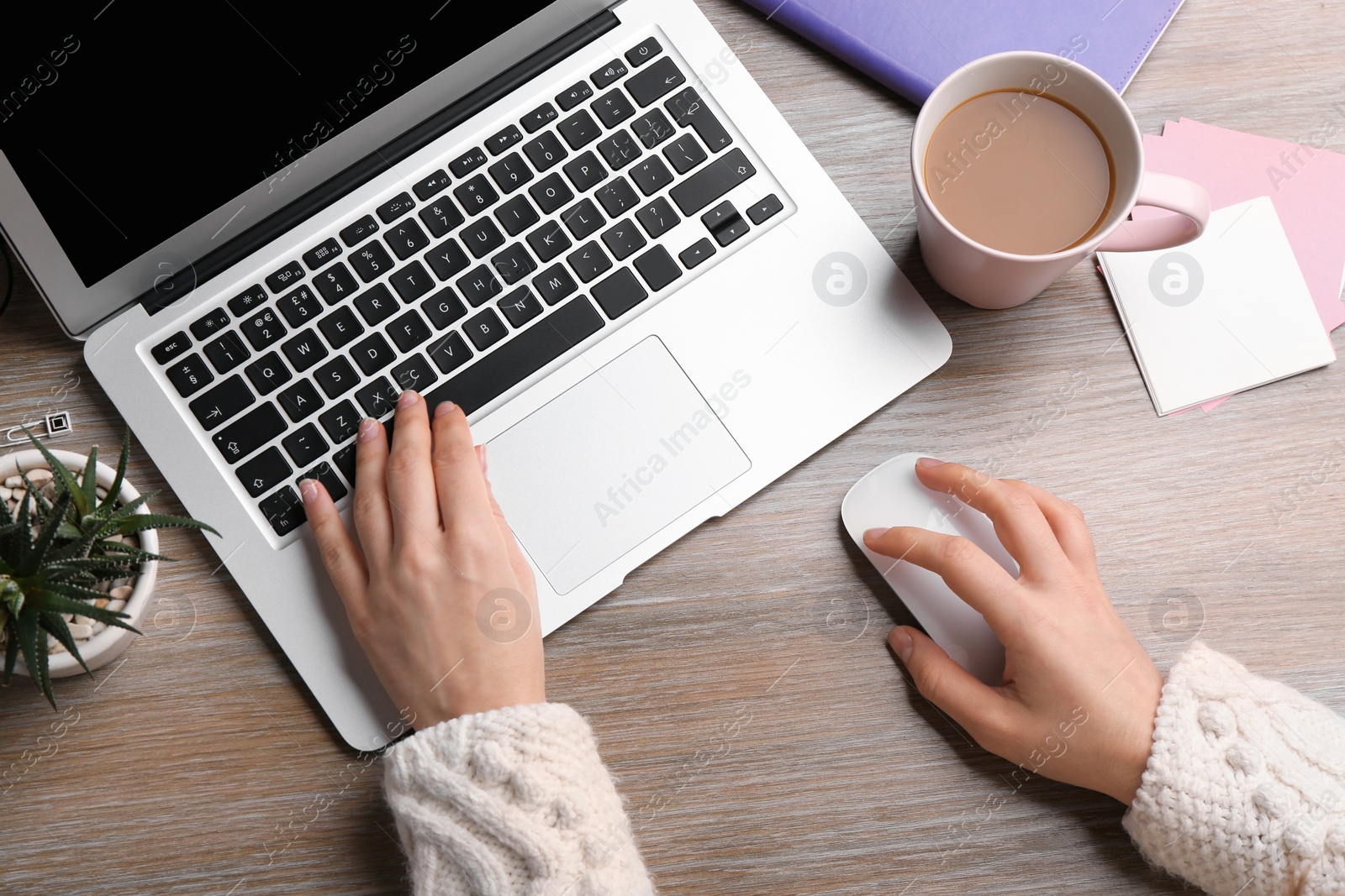 Photo of Woman using computer mouse with laptop at office table, top view