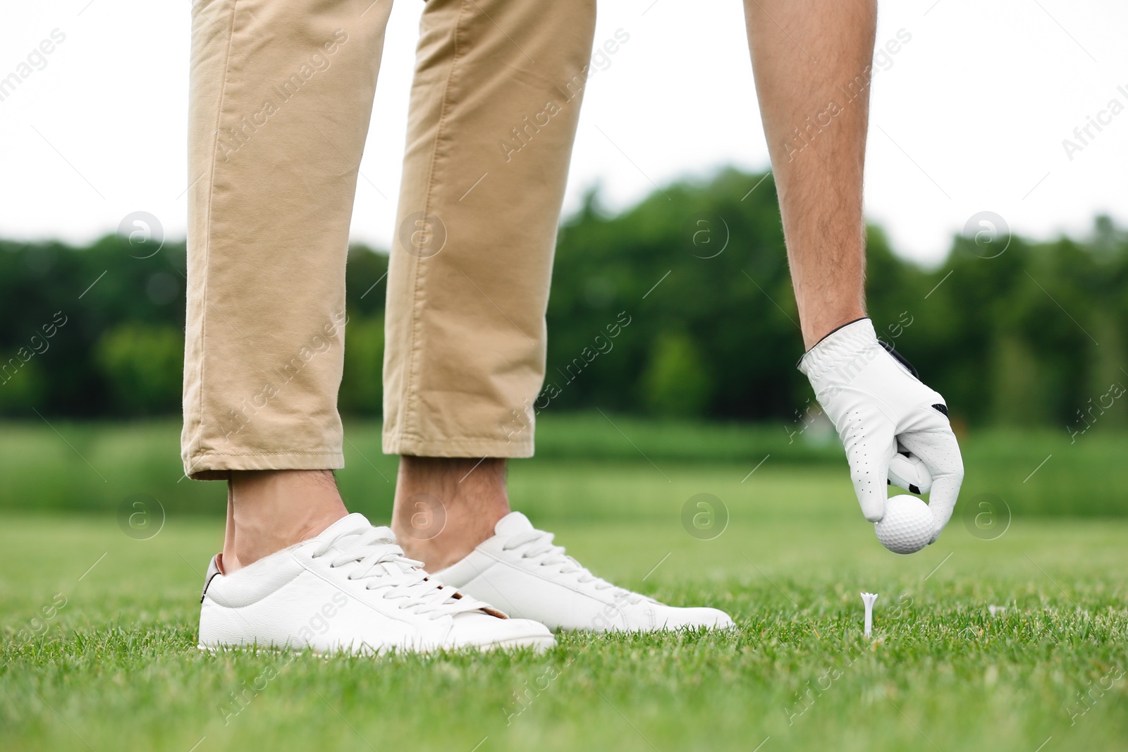 Photo of Man playing golf on green course. Sport and leisure