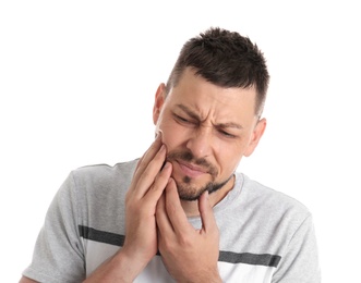 Man suffering from toothache on white background