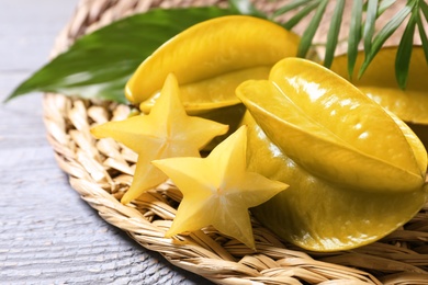 Photo of Delicious carambola fruits on light grey wooden table