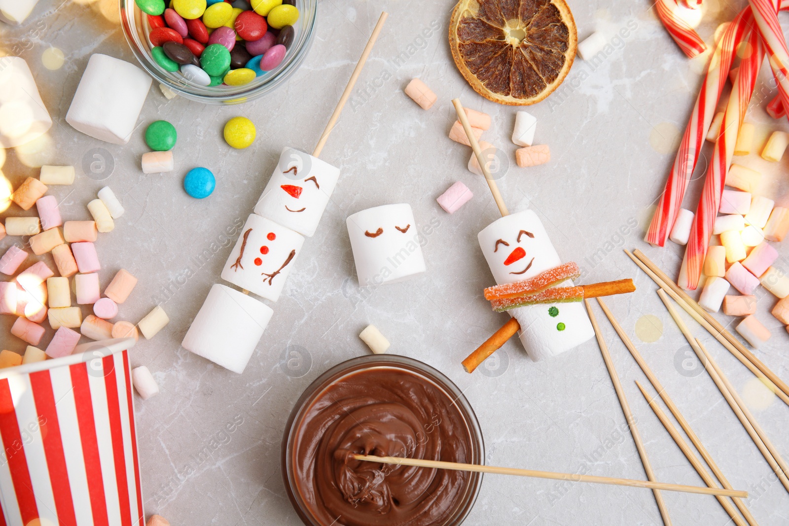 Image of Flat lay composition with funny snowmen made of marshmallows on light marble table. Bokeh effect 